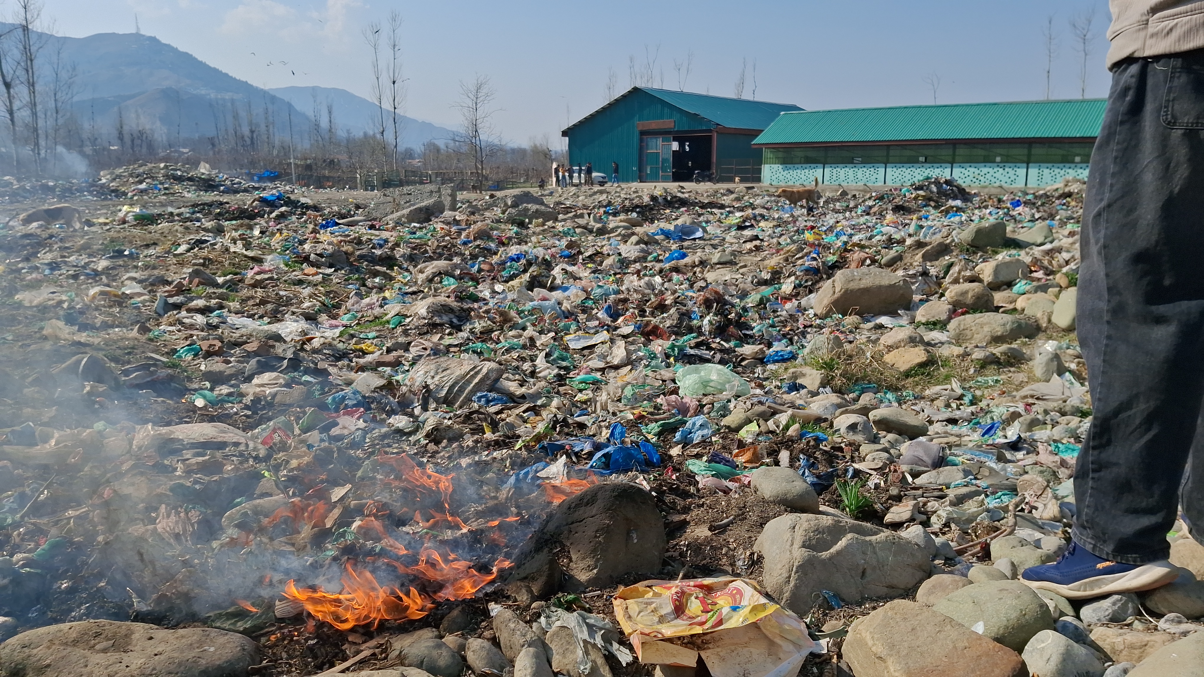 سالڈ ویسٹ منیجمنٹ پلانٹ کے باہر جلتی ہوئی پلاسٹک جس کا دھواں زہر آلود ہوتا ہے