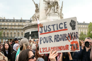 A protestor holds a sign reading "Justice for Aboubakar, Islamophobia kills" during a gathering in tribute to Aboubakar, the worshipper killed in a mosque at La Grand-Combe, and against Islamophobia, at the Place de la Republique in Paris on April 27, 2025.