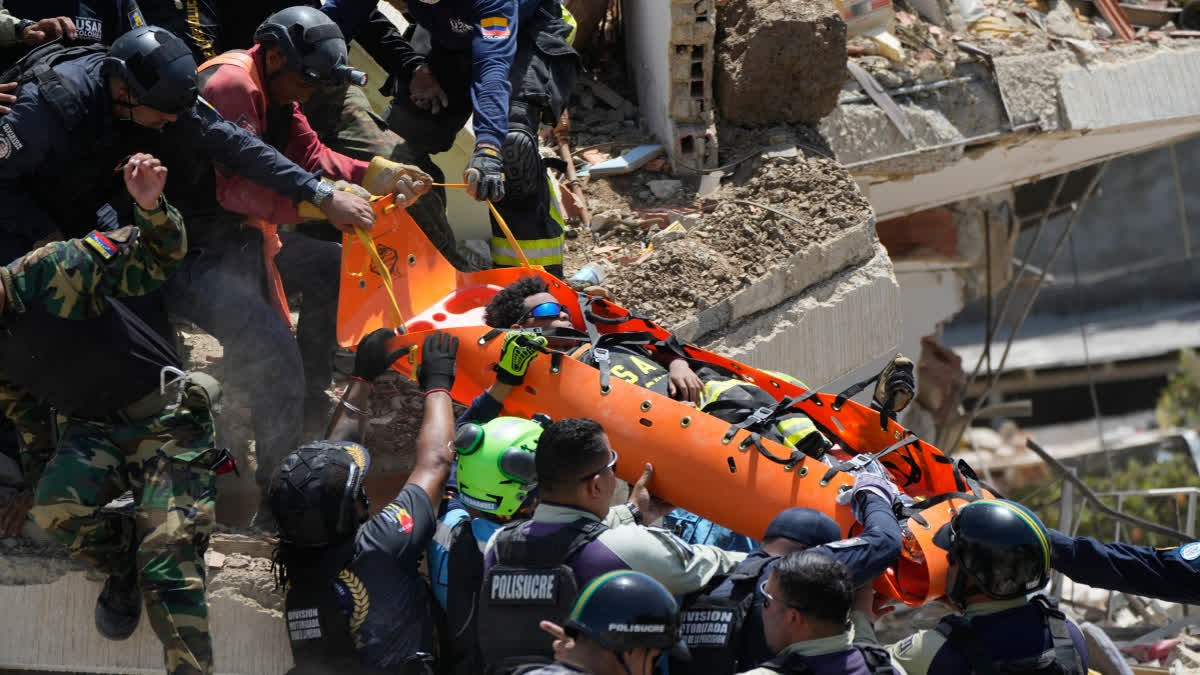 Rescue workers pull Moises Calzadilla, 11, from the rubble three days after earthquakes struck La Guaira, Venezuela, Saturday, June 27, 2026.