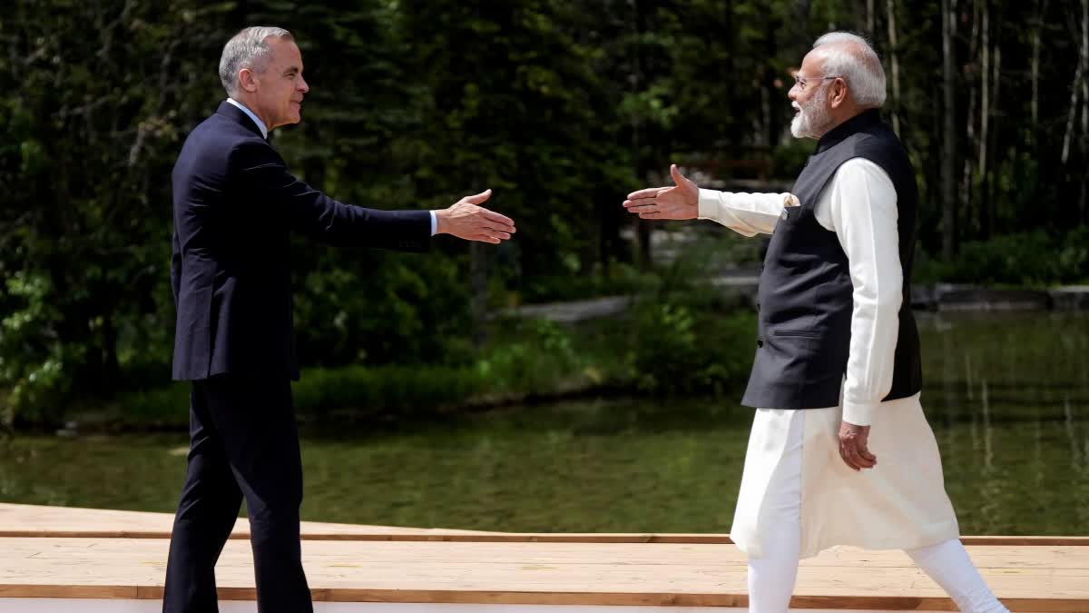 FILE - Canada's Prime Minister Mark Carney, left, and India's Prime Minister Narendra Modi reach to shake hands as Carney officially welcomes him to the G7 Summit in Kananaskis, Alberta, June 17, 2025