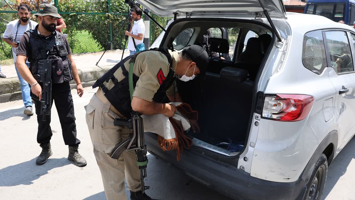 Security forces check a vehicle at a checkpoint in Kashmir