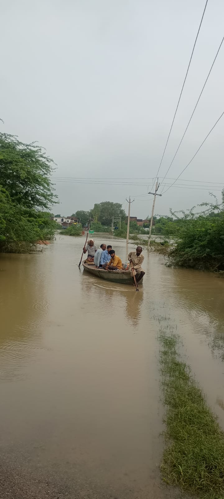 लारौंद गांव में नाव से नदी पार करते ग्रामीण.