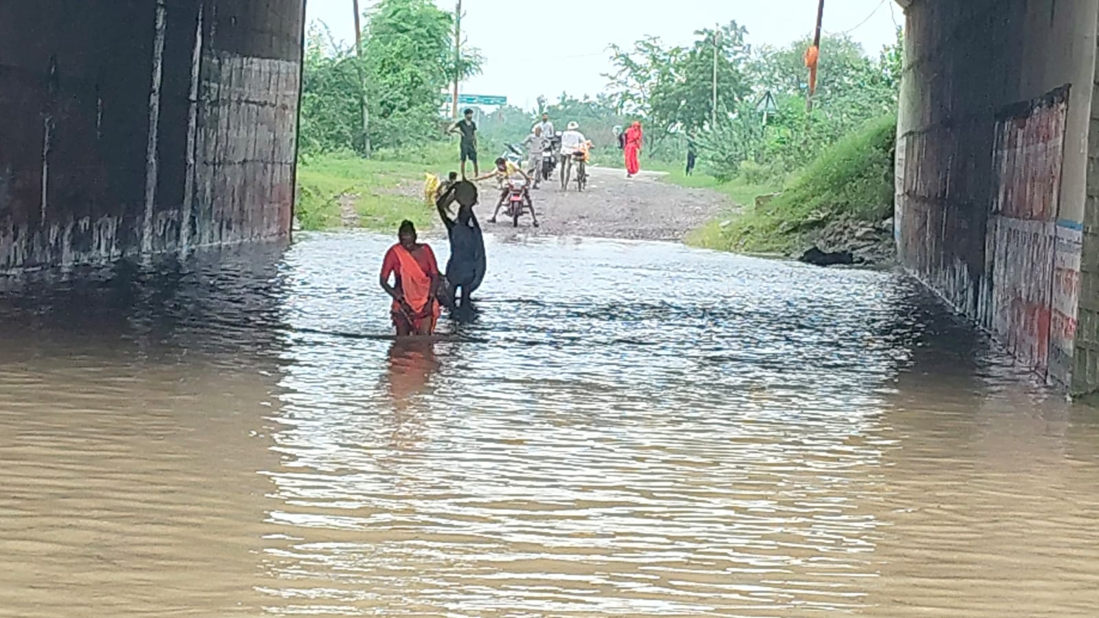 ग्राम कपसा में नहर अंडरपास में भरे पानी से निकलते राहगीर