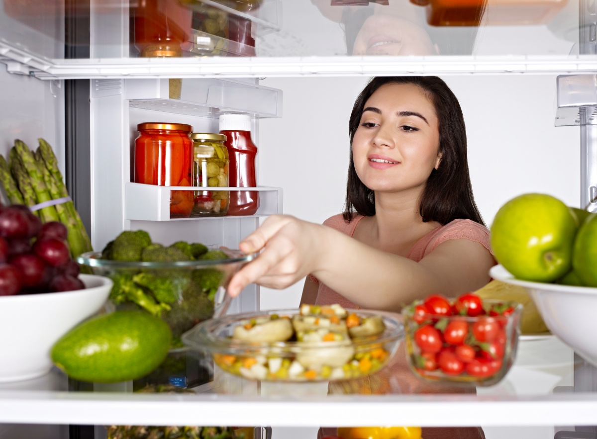 Woman taking out vegetables from the fridge