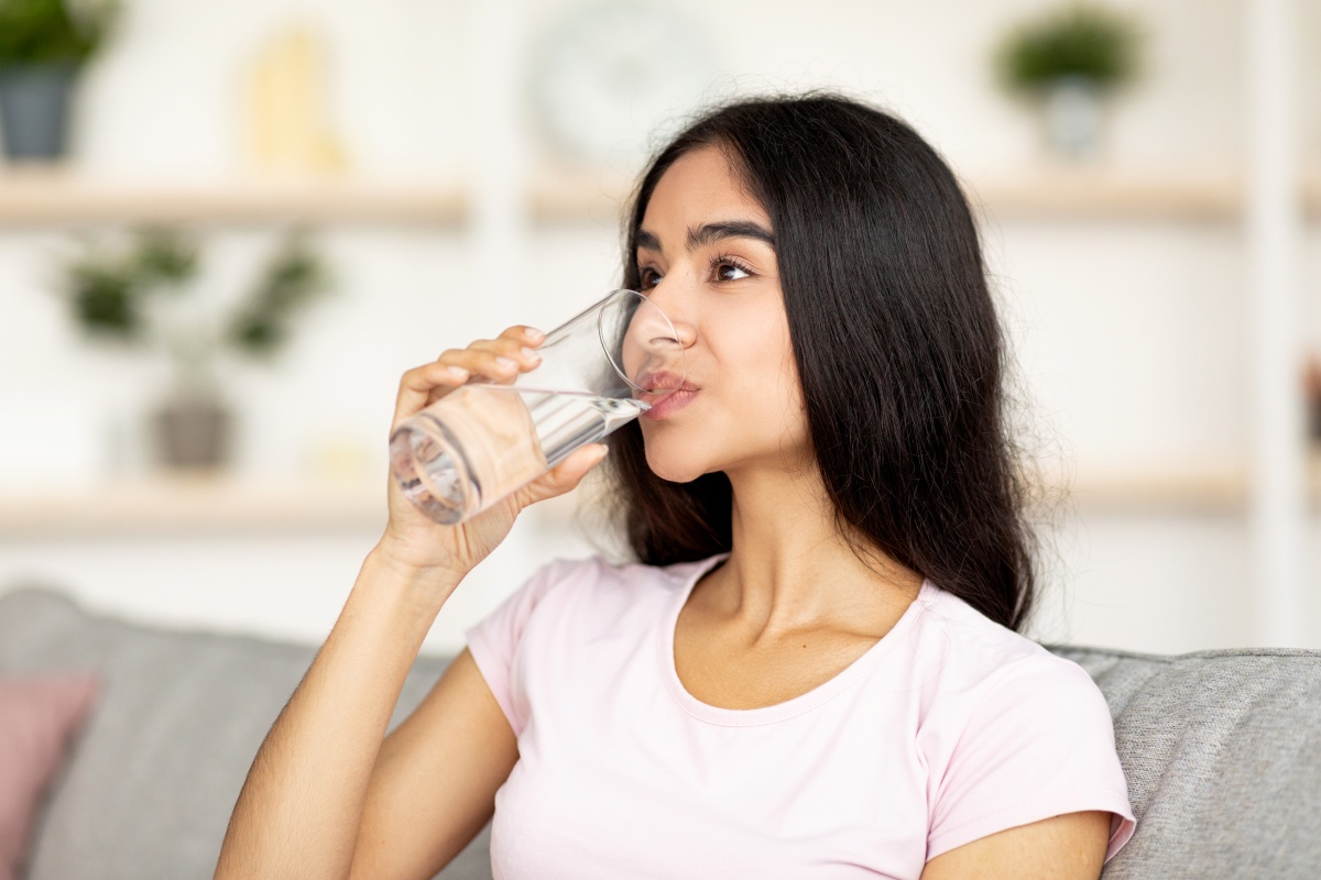 Young office employee drinking water