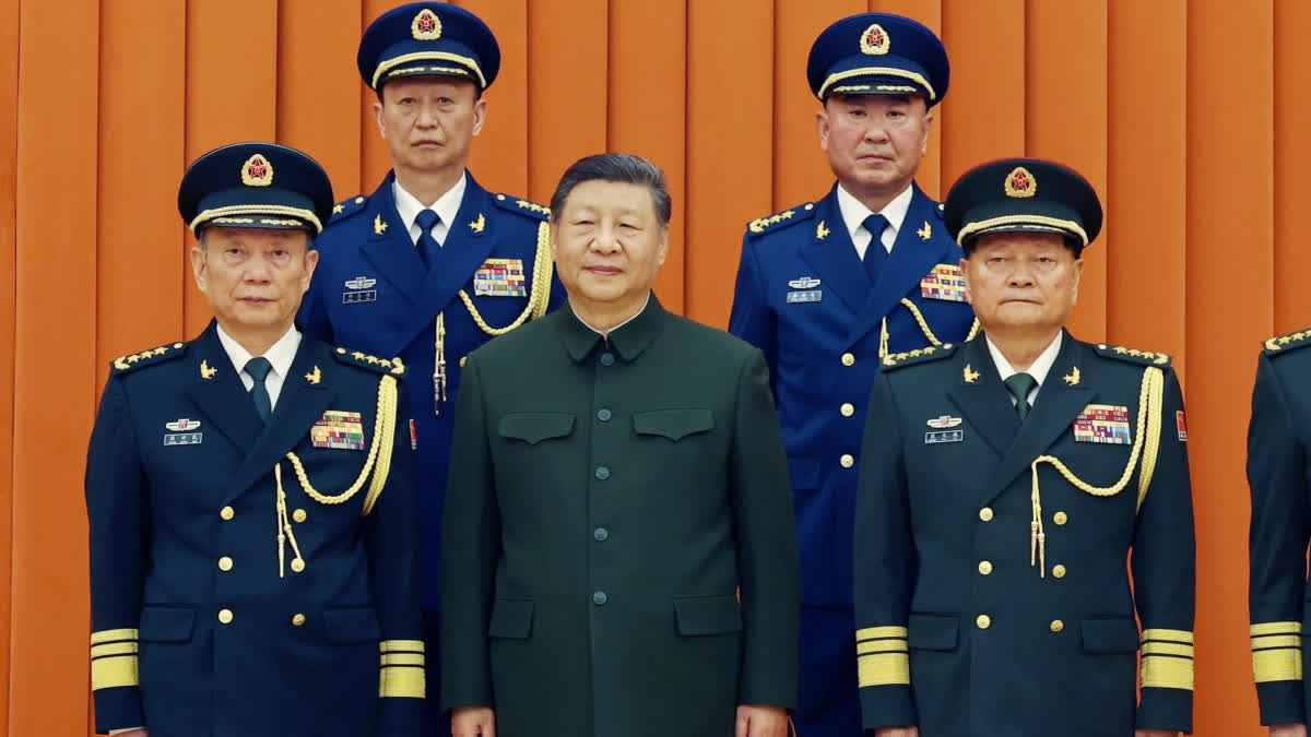 In this photo released by Xinhua News Agency, Chinese President Xi Jinping, also chairman of the Central Military Commission (CMC), front row second from left, poses with other military officers after promoting to generals, back row, from left, Yang Zhibin of the Eastern Theater Command and Han Shengyan commander of Central Theater Command in Beijing on Monday, Dec. 22, 2025.