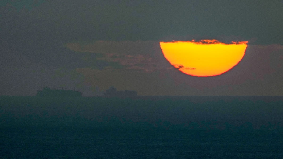 FILE - Ships sail through the Arabian Gulf toward the Strait of Hormuz as the sun sets in the United Arab Emirates Monday, March 23, 2026.