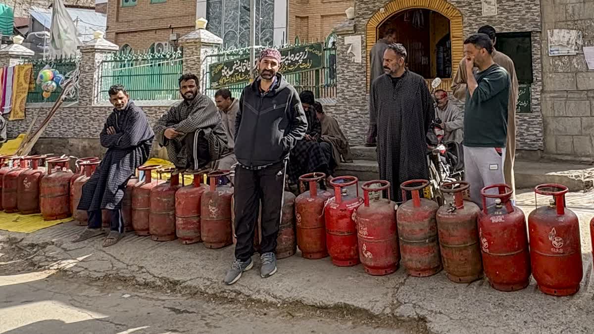 People wait with empty LPG cylinders to avail the refilled ones amid ongoing supply crisis, in Anantnag, Jammu and Kashmir