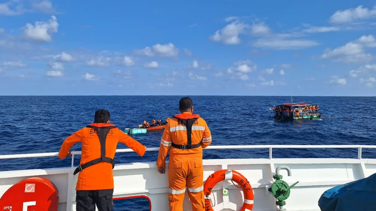 In this photo released by the Indonesian National Search and Rescue Agency (BASARNAS), crew look on as a rescue ship approaches a raft to evacuate the survivors boat that sank on Monday, in the waters off Taliabu Island, Indonesia, Tuesday, March 31, 2026.