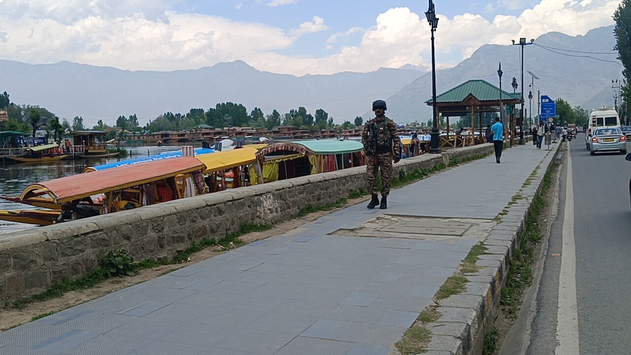 A paramilitary CRPF soldier walks along the boulevard on the banks of Dal Lake in Srinagar