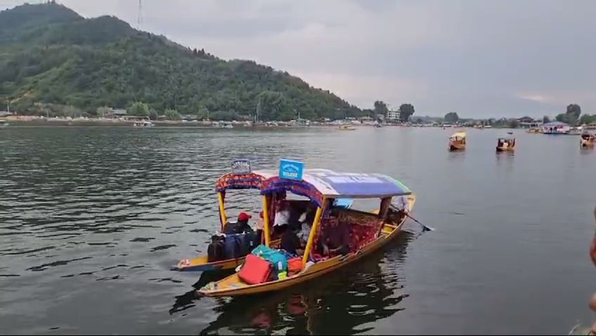 Shikaras in the iconic Dal Lake with houseboats in the backdrop in Srinagar