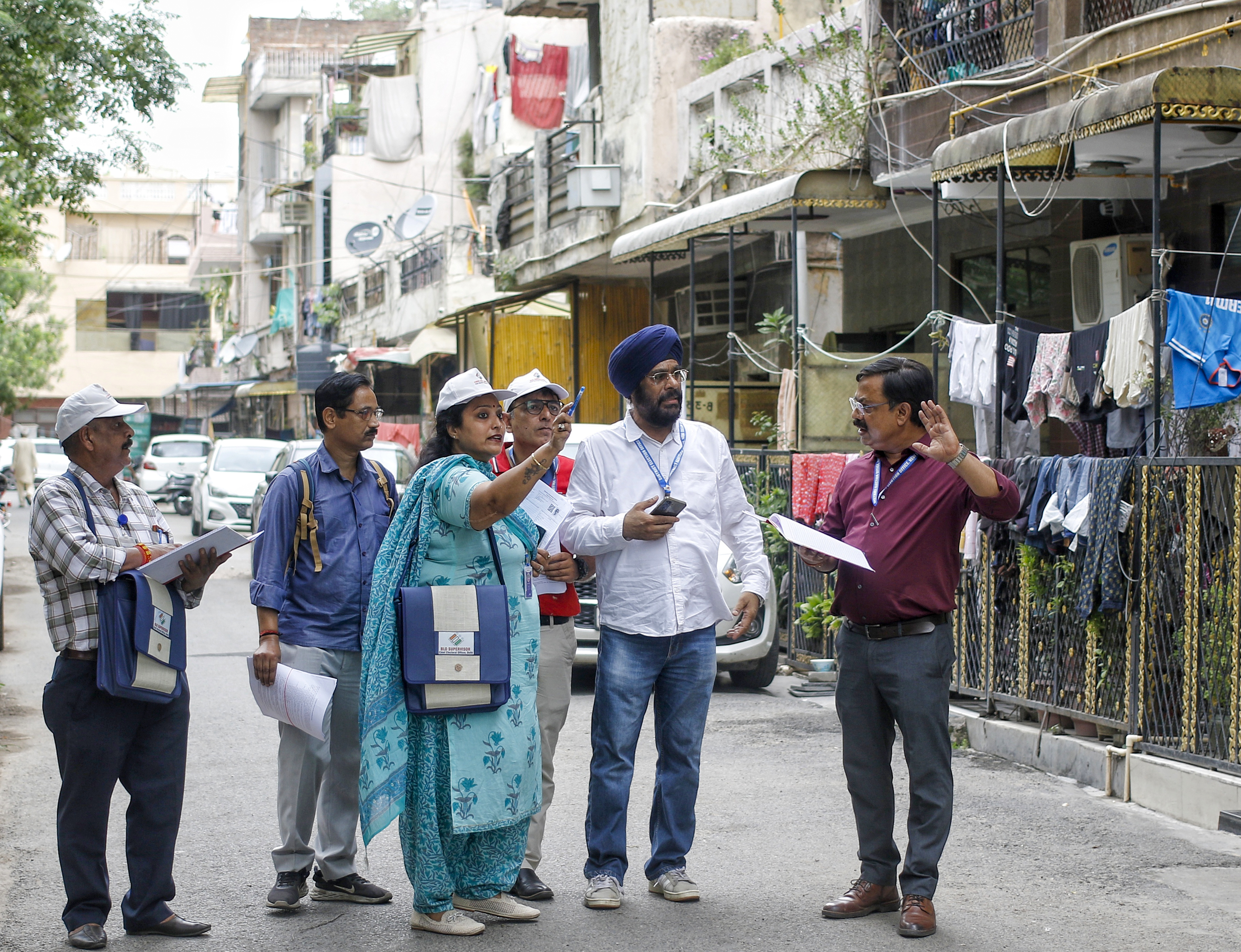 A Booth Level Officer (BLO) conducts the Special Intensive Revision (SIR) door-to-door voter verification drive at BK Dutt Colony, Jor Bagh, in New Delhi.