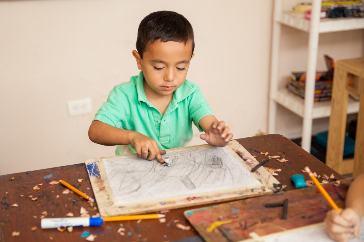 Little boy drawing with a pencil